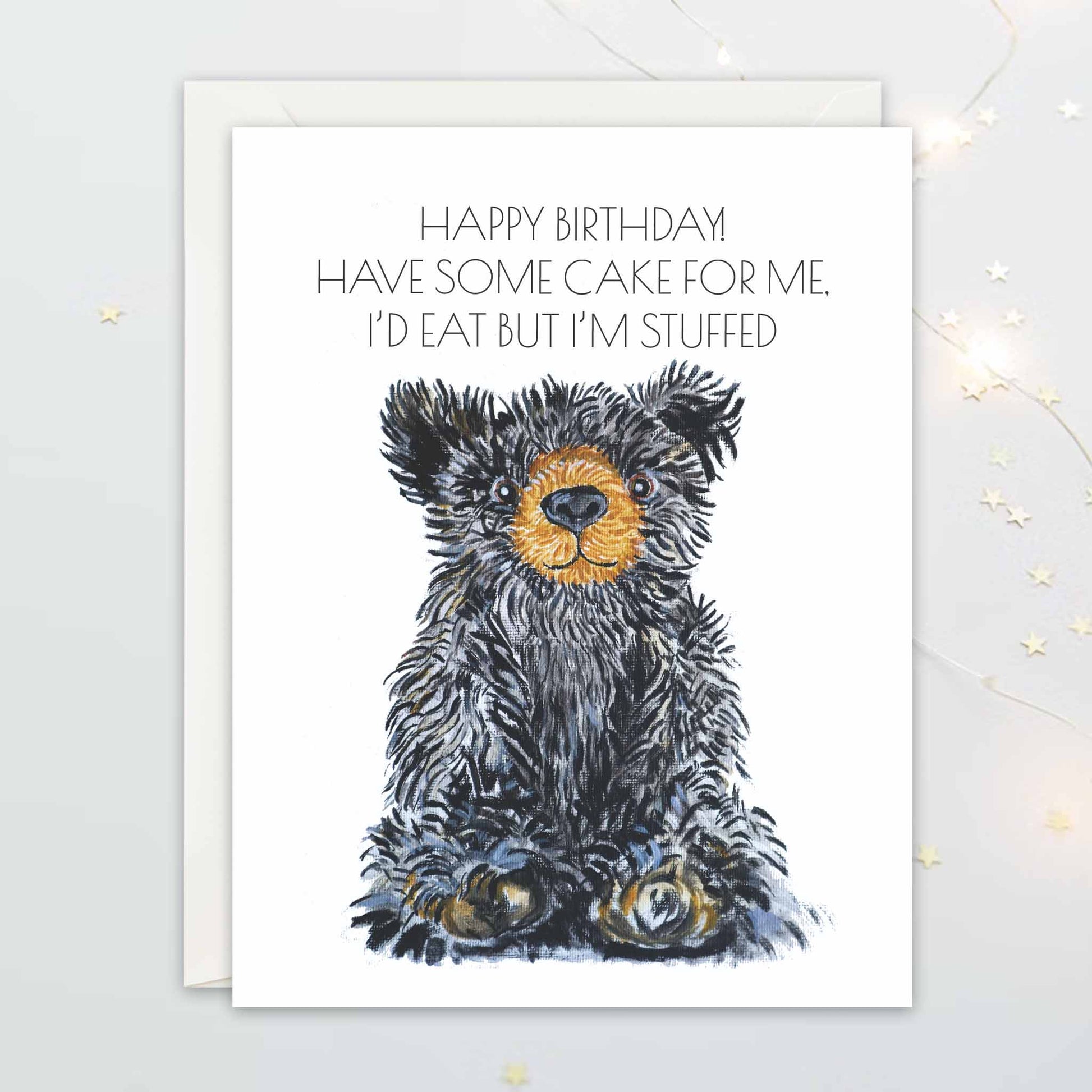 Birthday card with a teddy bear illustration and humorous text on a white background: "Happy Birthday! Have some cake for me. I'd eat but I'm stuffed"