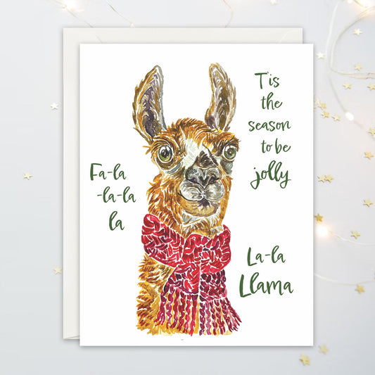 Holiday card with a llama wearing a red scarf and text that say "T'is the Season to be jolly, fa-la-la-la-la-la-la-llama"