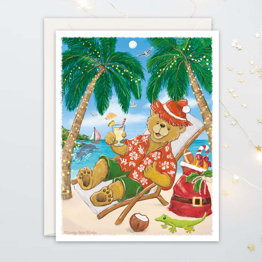 Greeting card illustration of a bear in a red Hawaiian shirt lounging on a beach with palm trees and a Santa sack in the background.