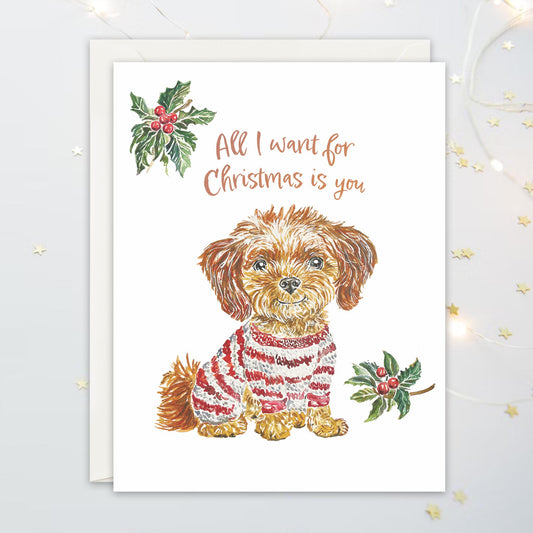Christmas card with a dog wearing a sweater and holly leaves on a white background