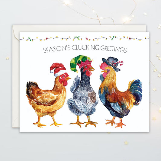 Greeting card with three chickens wearing hats and 'Season's Clucking Greetings' text on a white background.