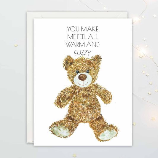 Card with a teddy bear illustration and text on a white background with texts "You make me feel all warm and fuzzy"