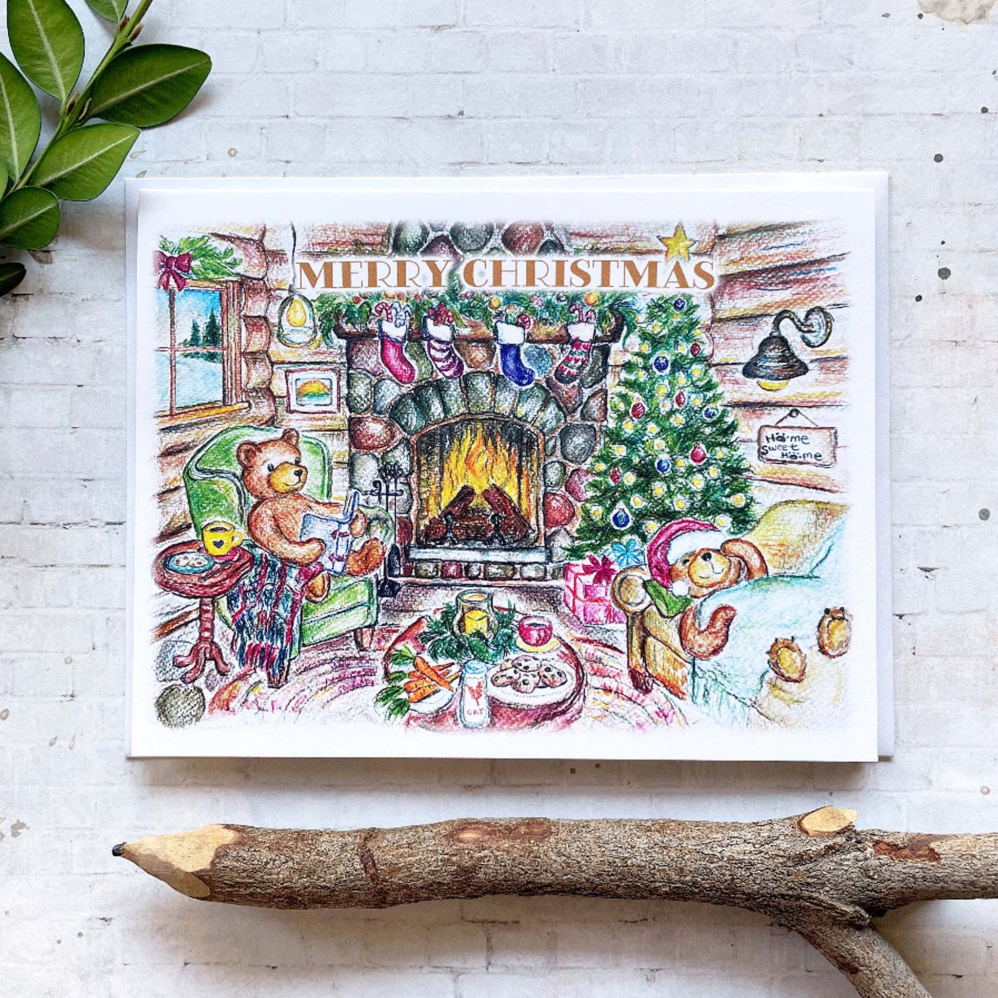 Colorful Christmas card with teddy bears by a fireplace on a white surface.