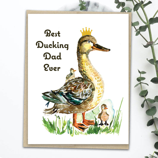 A greeting card with a hand-drawn illustration of a duck and two ducklings on a grassy background, with the text 'Best Ducking Dad Ever'.