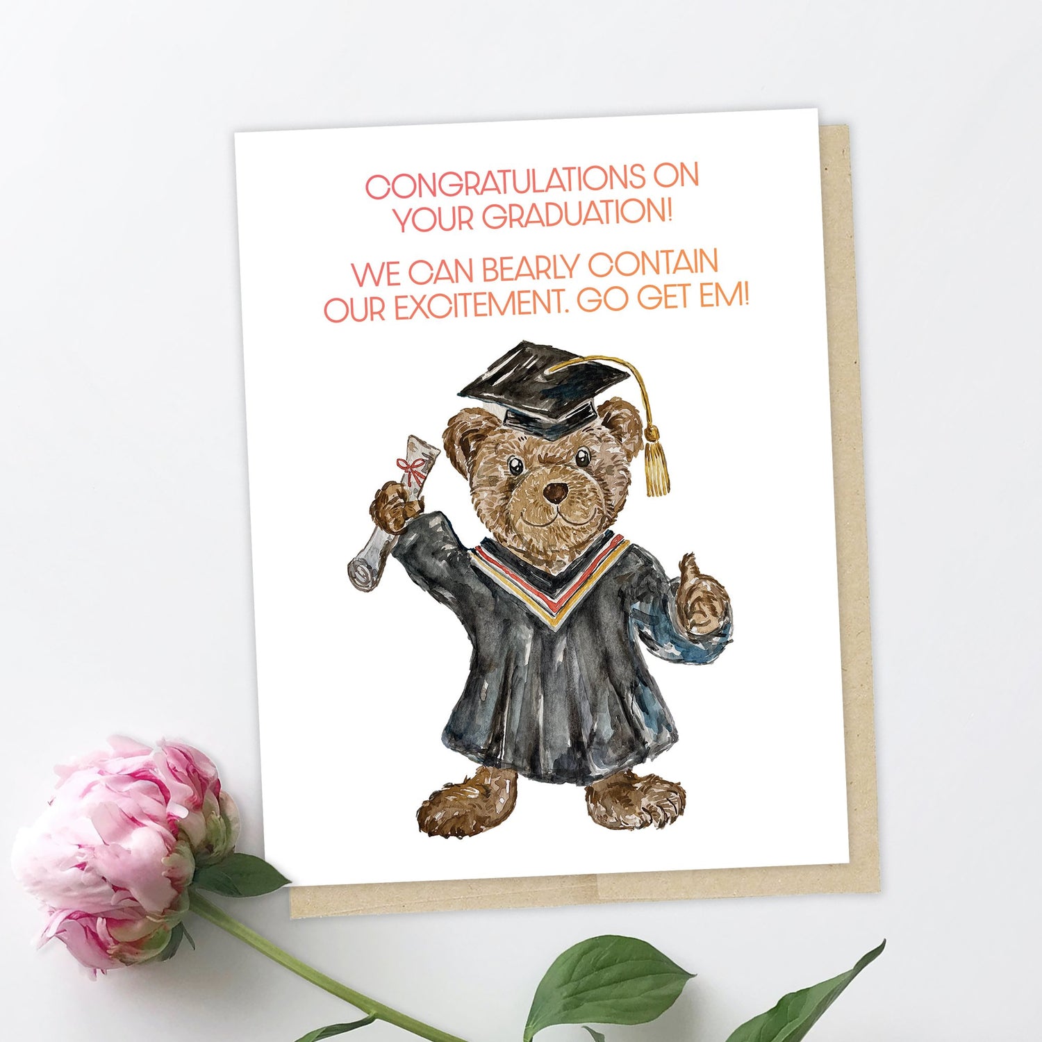a greeting card of a cute bear in convocation gown, square hat, one hand in the air holding a diploma, other paw with a thumbs up. it says "congratulations on your graduation! we can bearly contain our excitement. go get em!"