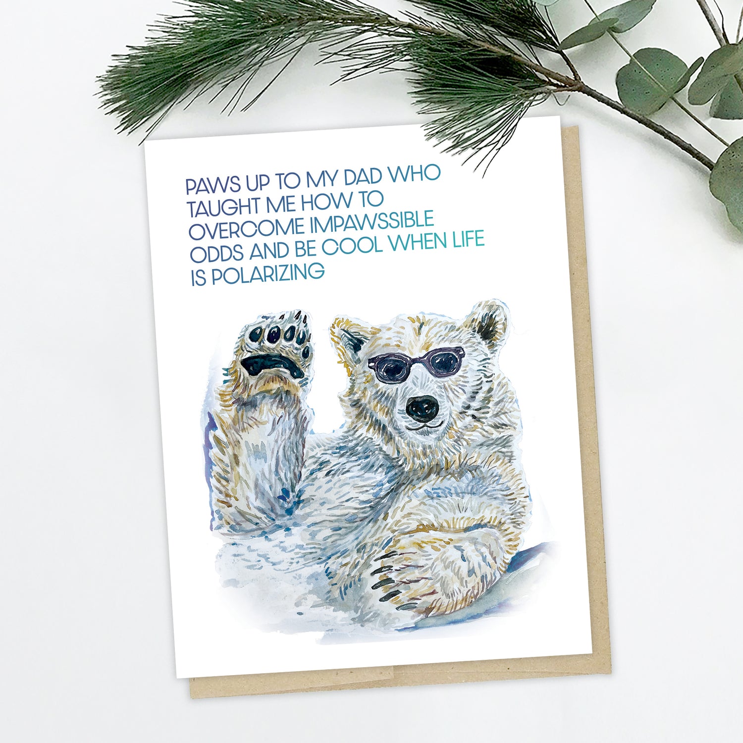 A greeting card for dad with a hand painted polar bear in sunglasses, it says "Paws up to my dad who taught me how to overcome impawssible odds and be cool when life is polarizing"