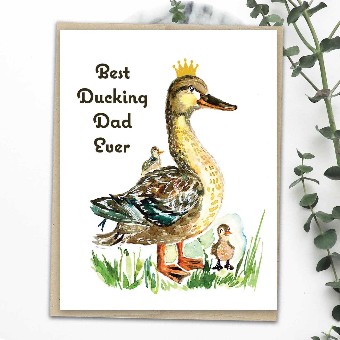 A greeting card with a hand-drawn illustration of a duck and two ducklings on a grassy background, with the text 'Best Ducking Dad Ever'.