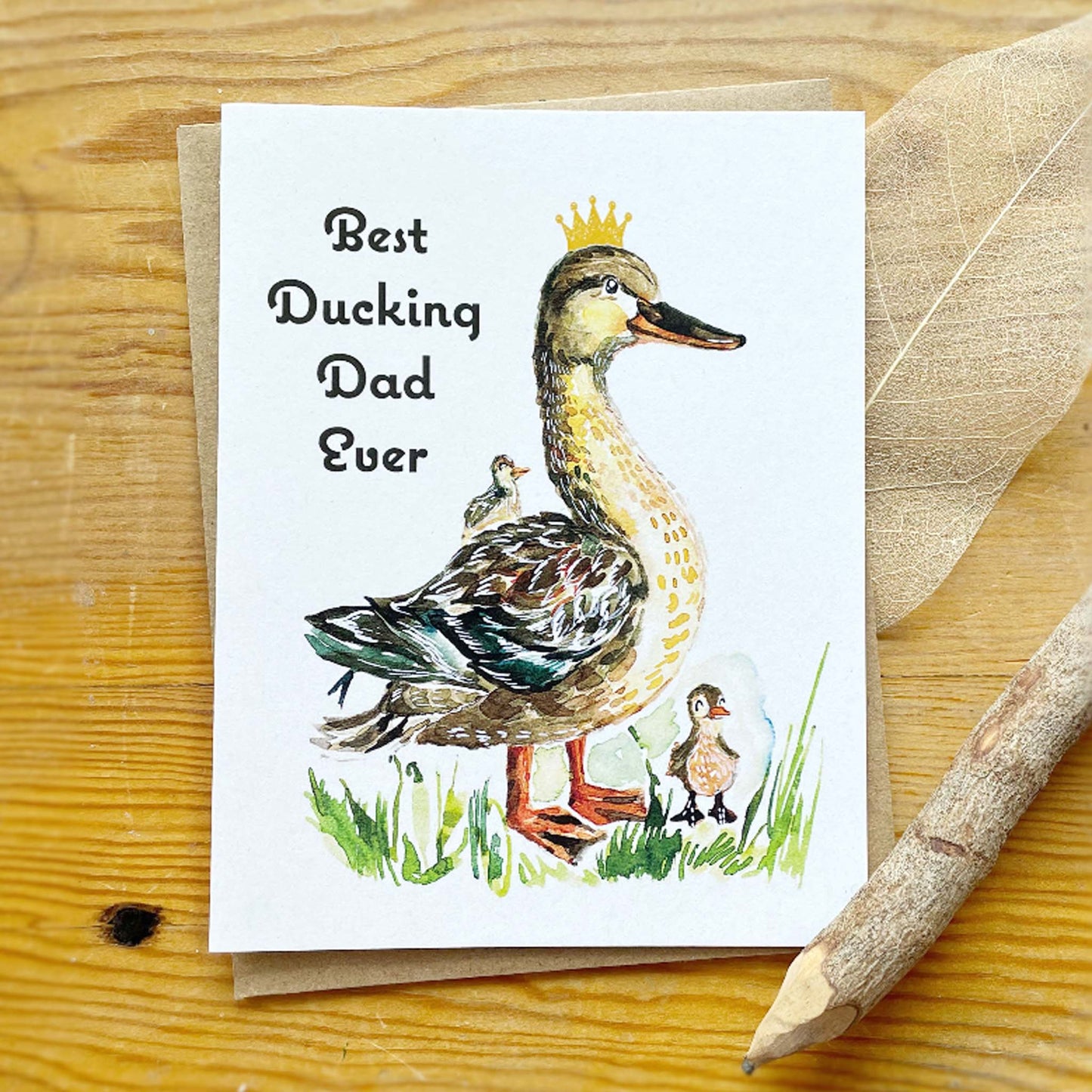 Greeting card with a duck illustration and text on a wooden surface