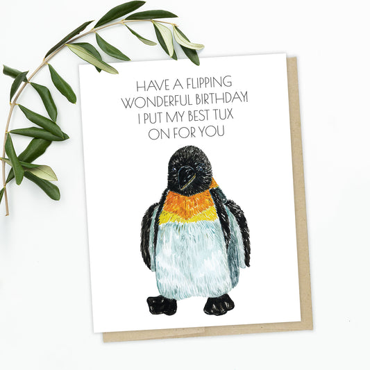 A picture of a greeting card. A fuzzy emperor penguin standing with its flippers along his sides. The text reads: Have a flipping wonderful birthday! I put my best tux on for you. 